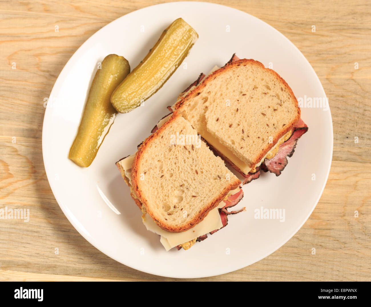 Pastrami Sandwich auf jüdische Roggenbrot mit Schweizer Käse, Senf und koscher Dill pickles Stockfoto