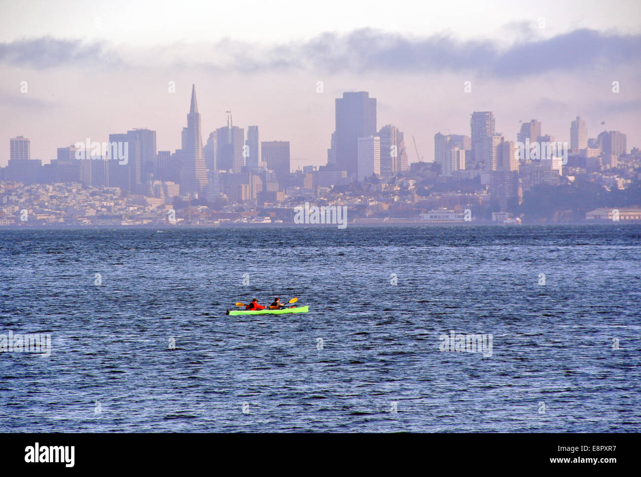 zwei Frauen paddeln Kajak an der San Francisco Bay mit Skyline im Hintergrund Stockfoto