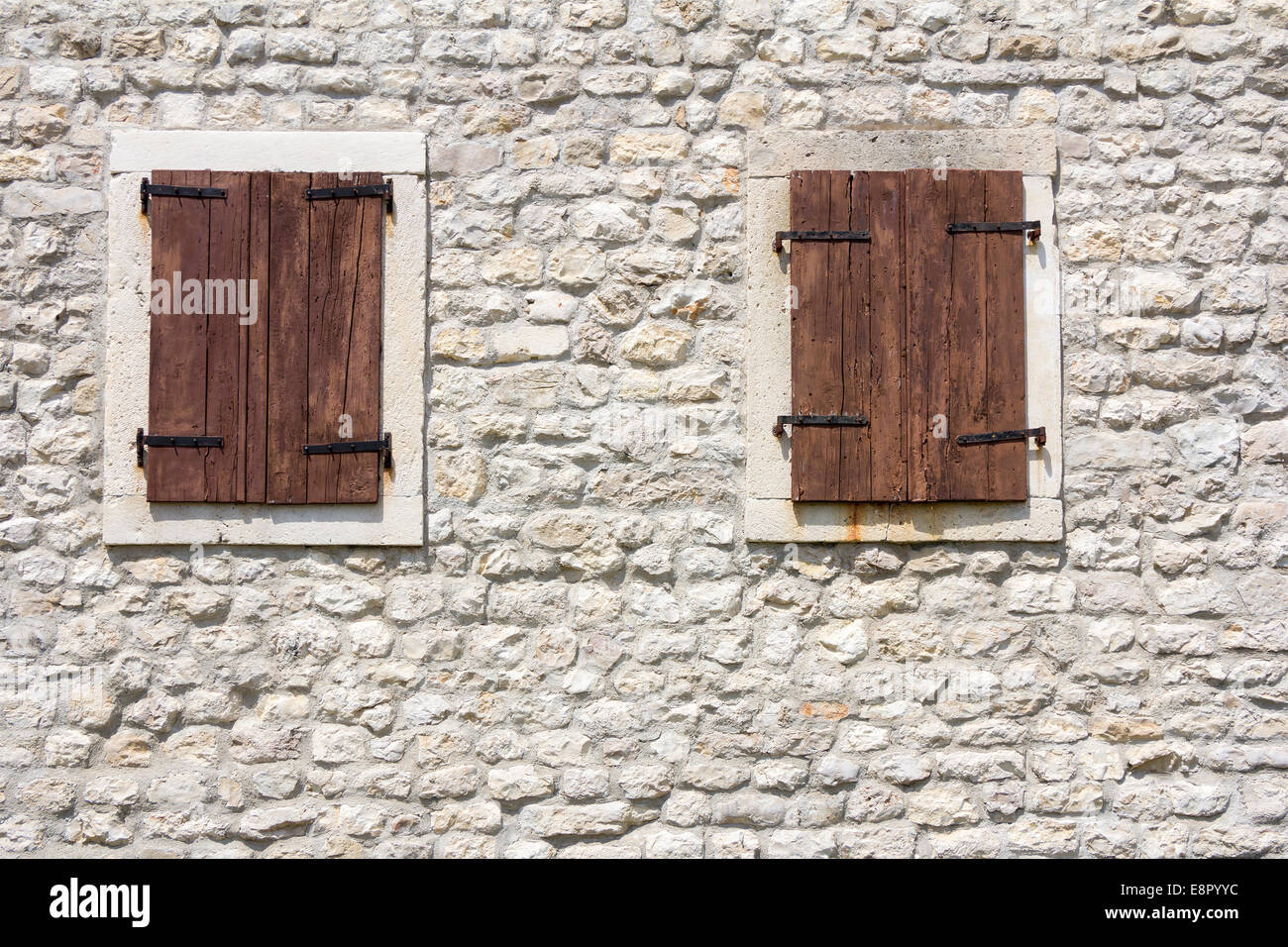 Alte Holzfenster in der alten Steinmauer Stockfoto