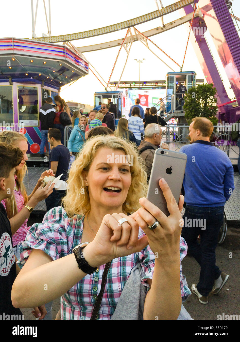 Stuttgart, Deutschland - 4. Oktober 2014: Ist eine im mittleren Alter Frauen im traditionellen Dirndl Kleid nehmen Selfie mit den neuen Apple iPhon Stockfoto