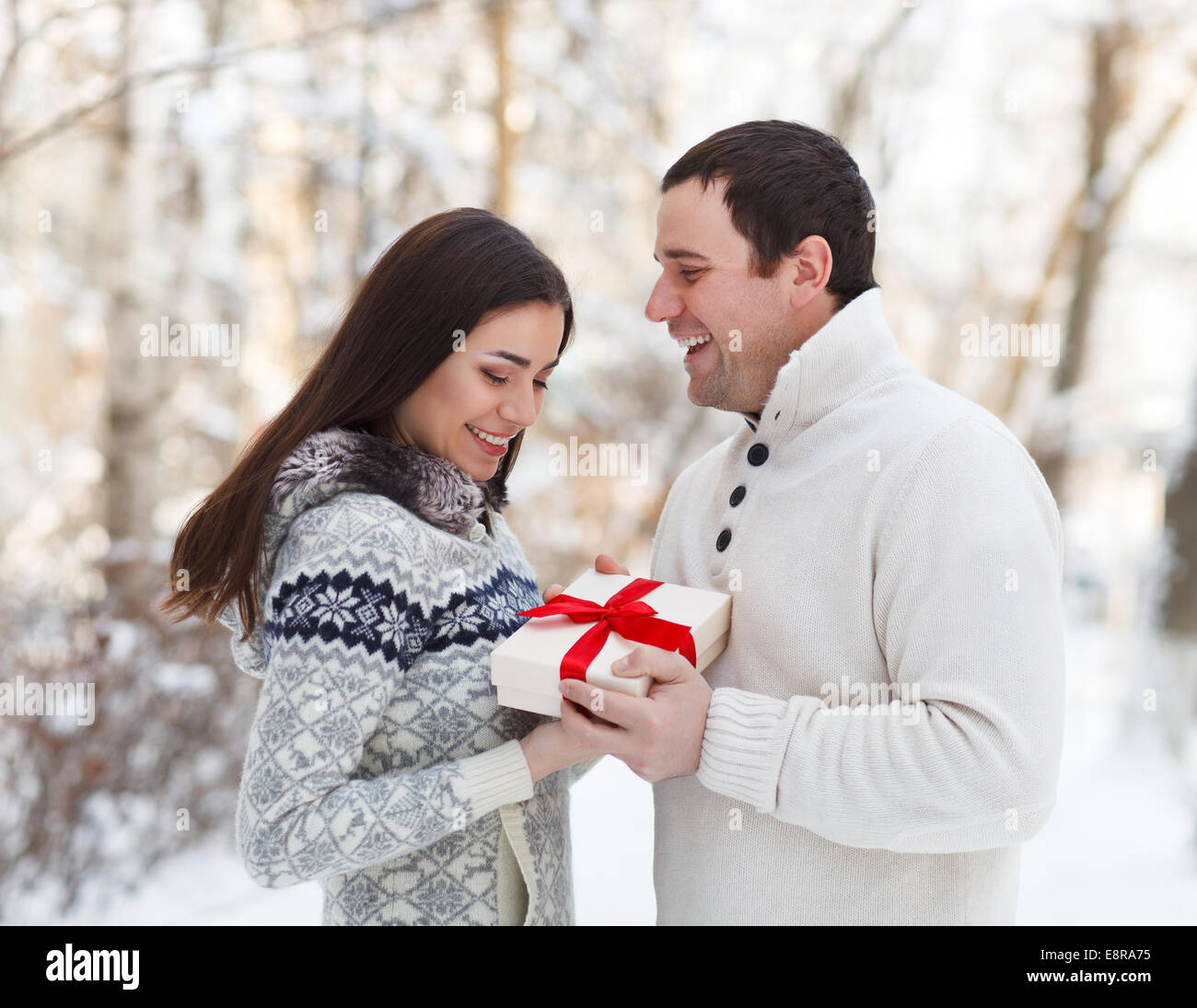 Glückliches junges Paar verliebt in Gegenwart Spaß im Winter Park Stockfoto
