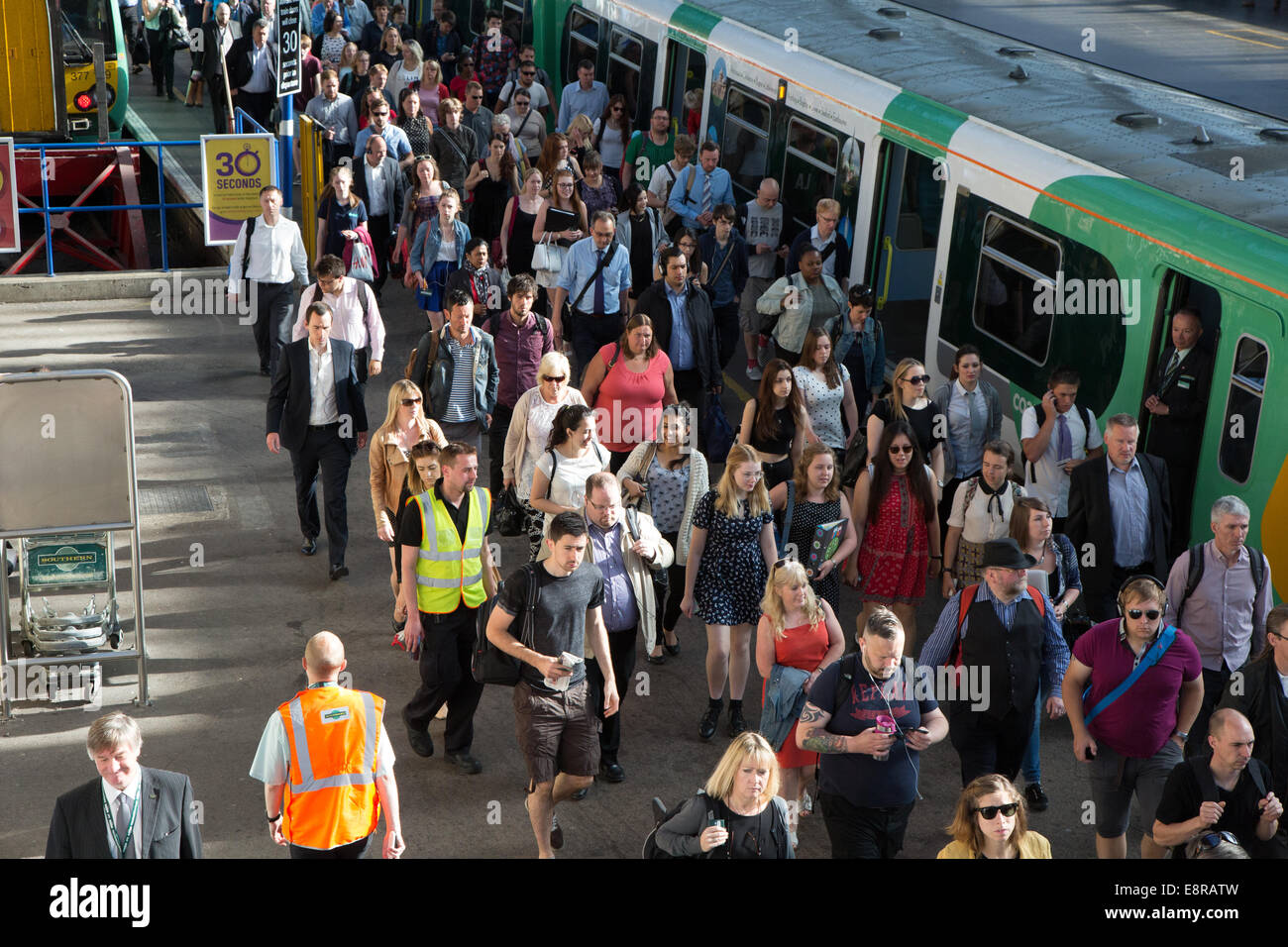 Fahrgäste Züge aussteigen und zu Fuß in Richtung ticket am Bahnhof Brighton Tore während einem anstrengenden Sommermorgen. PKW Stockfoto