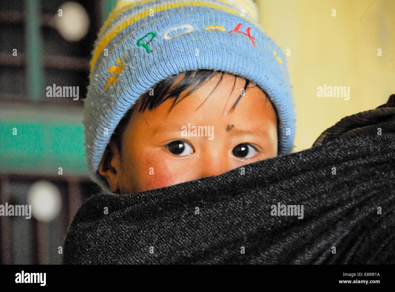 Kind von Mutter im Tuch auf dem Rücken, Indien durchgeführt Stockfoto