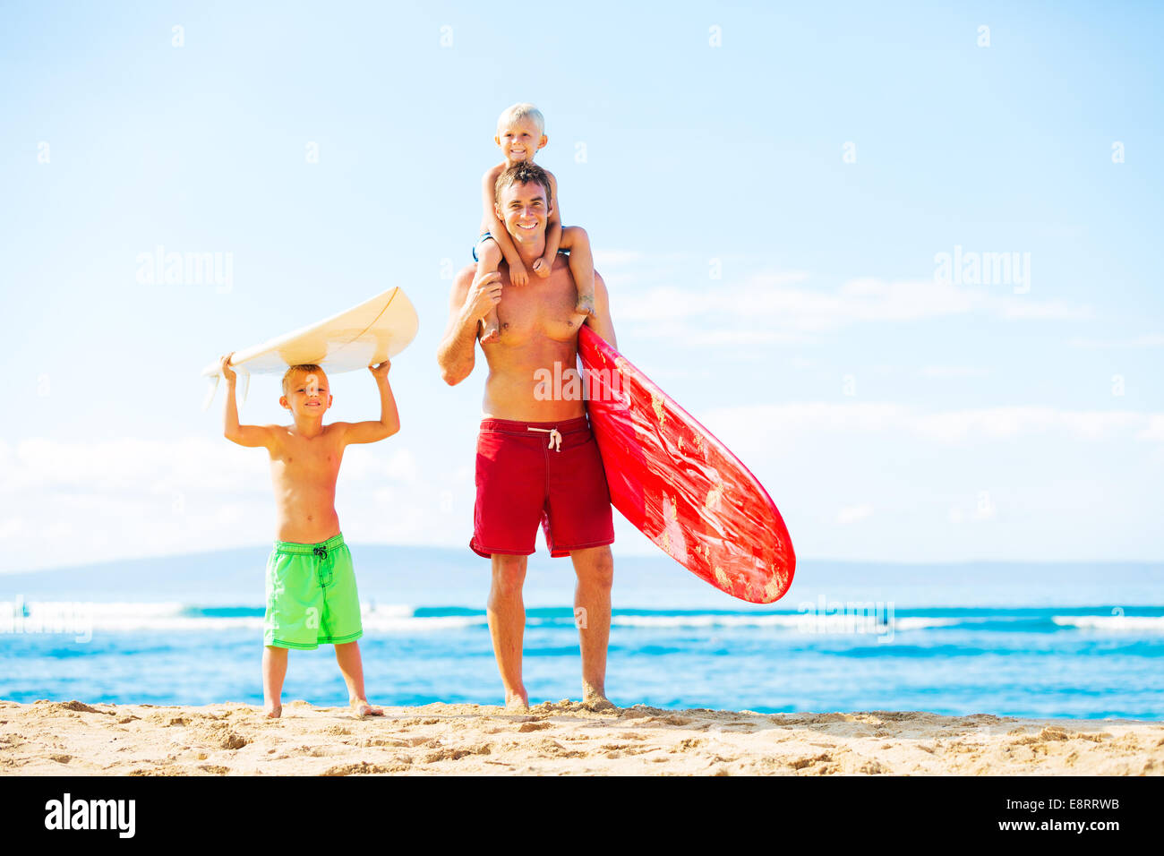 Vater und Söhne am Strand surfen Stockfoto
