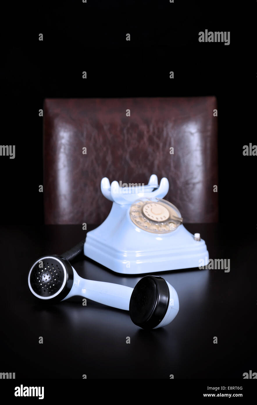 Offenen blauen Telefon über den Tisch auf dem schwarzen Hintergrund Stockfoto