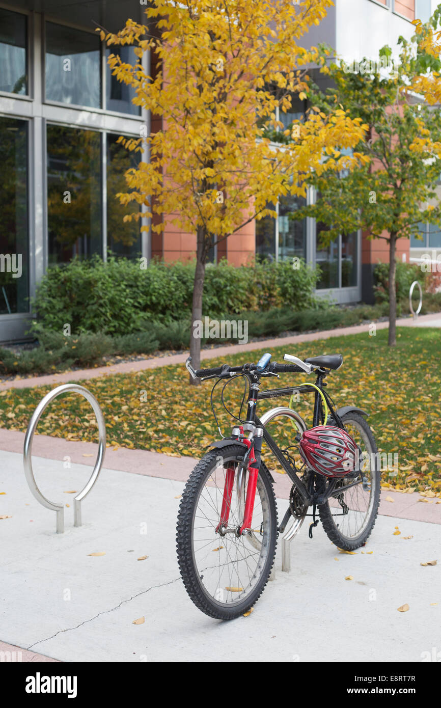 Fahrrad mit Helm im Herbst auf dem Campus der Community College geparkt Stockfoto
