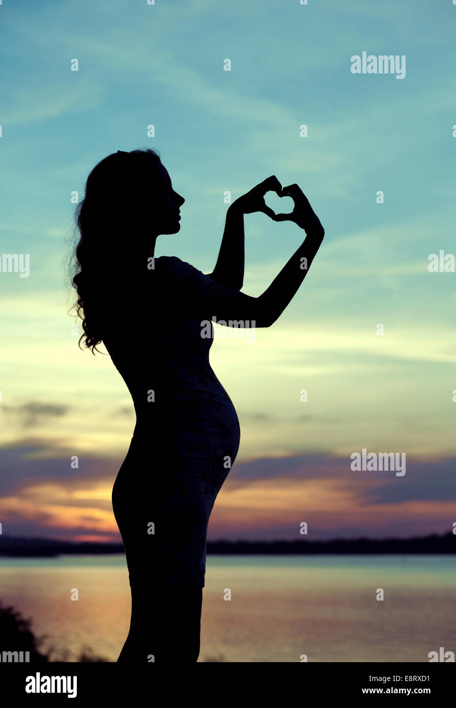 Schwangere Mutter machte das Herz Zeichen Stockfoto