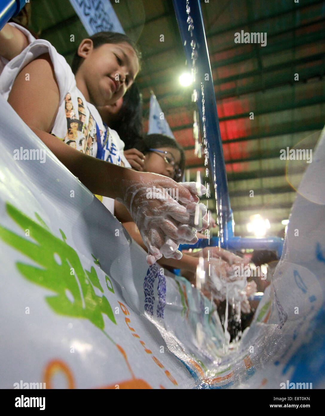 Mandaluyong City, Philippinen. 14. Oktober 2014. Kinder waschen ihre Hände auf die Global Handwashing Day in Mandaluyong City, Philippinen, 14. Oktober 2014. Der Global Handwashing Day soll motivieren, mobilisieren und das Bewusstsein für Händewaschen mit Seife, um die Ausbreitung von Krankheiten zu verhindern. © Rouelle Umali/Xinhua/Alamy Live-Nachrichten Stockfoto