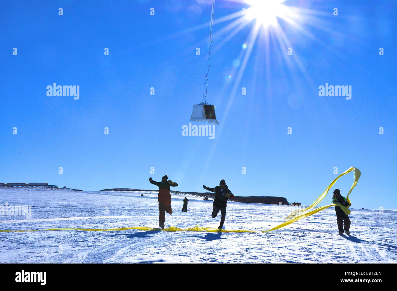 Lauf-Team-Mitglieder laufen unter der Nutzlast, wie der Ballon zuerst Flug an der SANAE IV-Forschungsstation in der Antarktis nimmt. Stockfoto