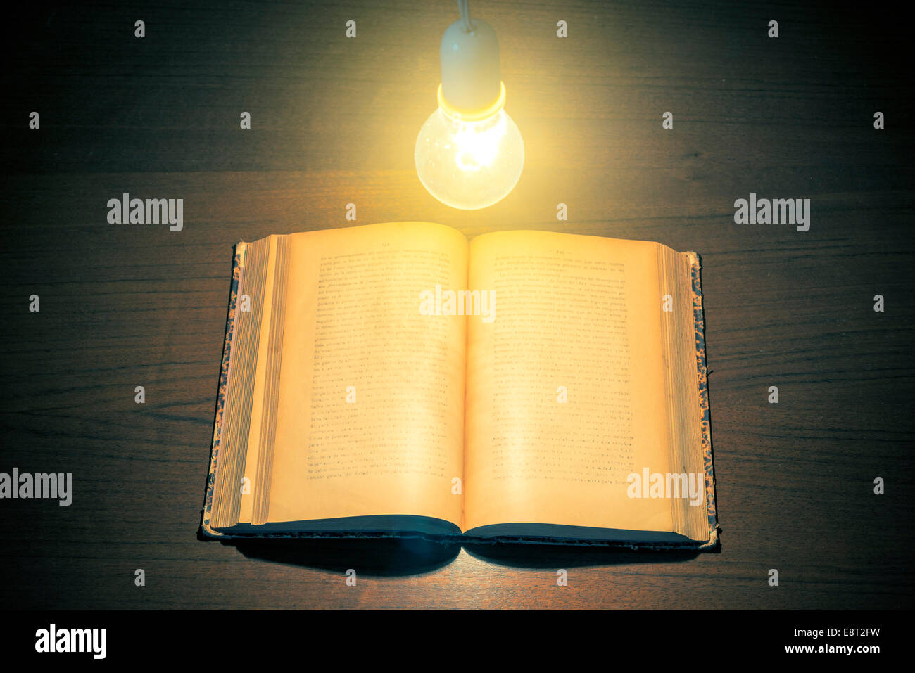 Glühbirne beleuchtet ein Buch Stockfoto
