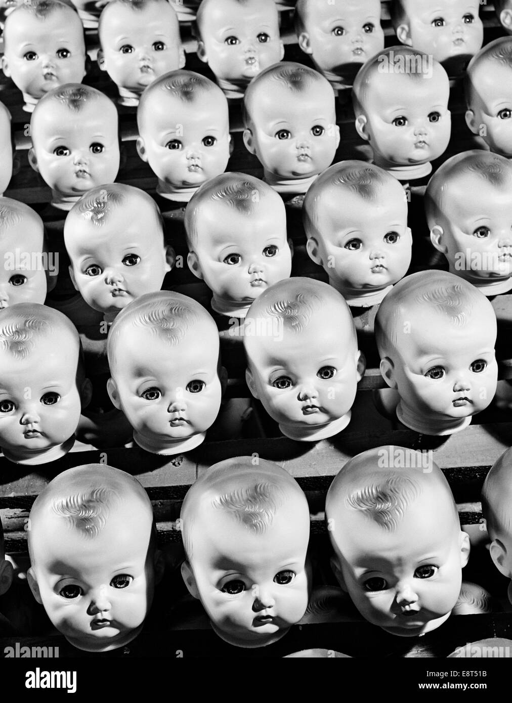 1950ER JAHREN REIHEN VON BABY PUPPENKÖPFE IN DER PRODUKTIONSLINIE Stockfoto