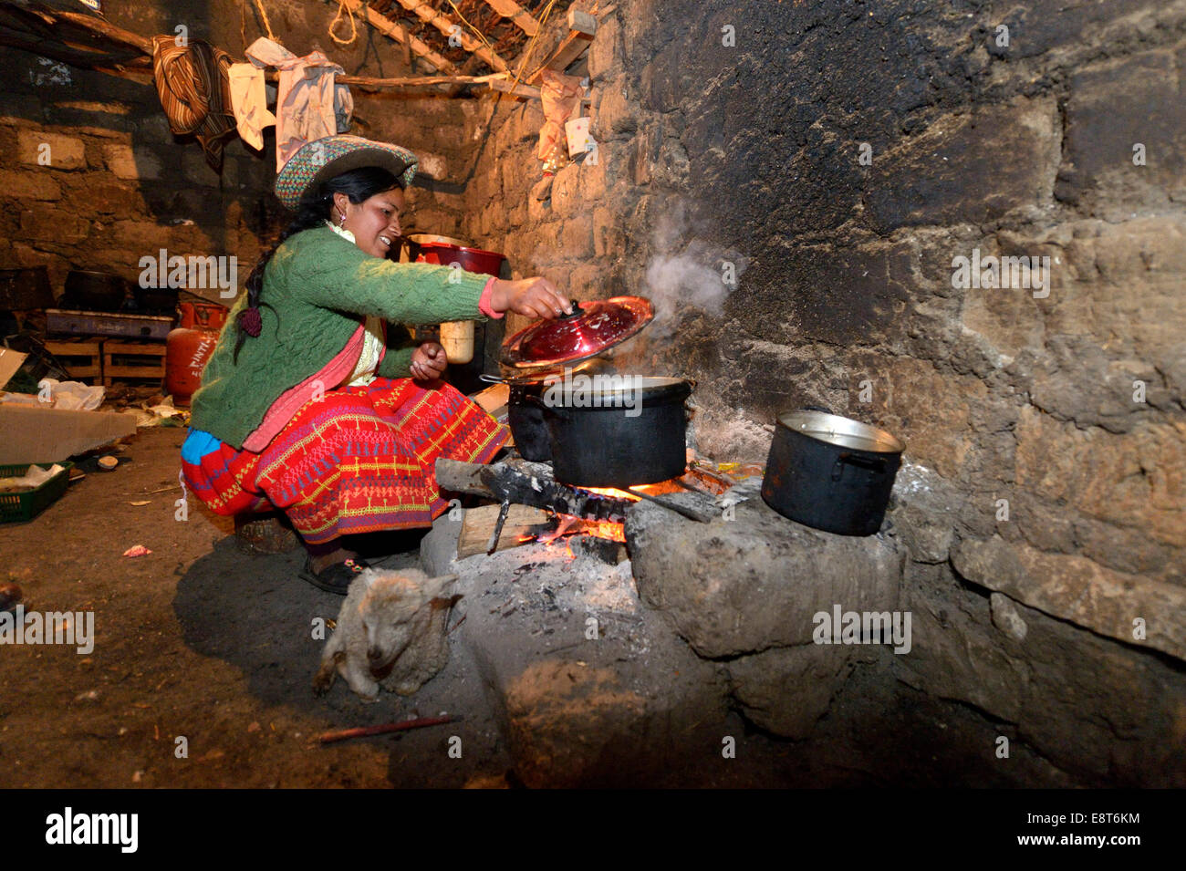 Junge Frau, die das Kochen auf offenem Feuer in ihrer traditionellen Küche, Union Potrero, Quispillacta, Ayacucho, Peru Stockfoto