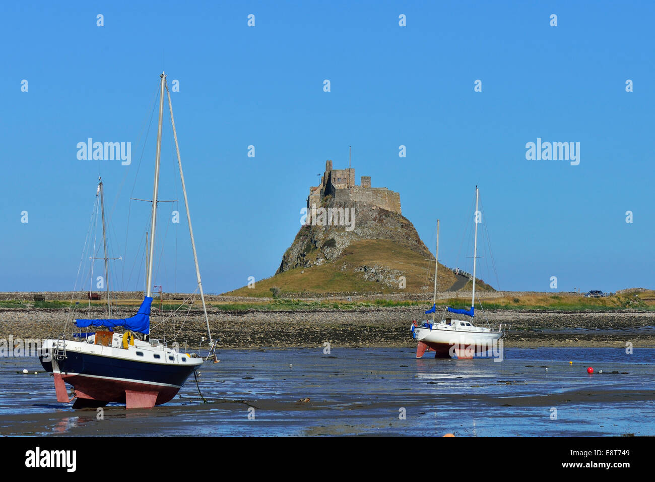 Segelboote bei Ebbe in der Bucht von Lindisfarne Castle, Lindisfarne, Northumbria, England, Vereinigtes Königreich Stockfoto