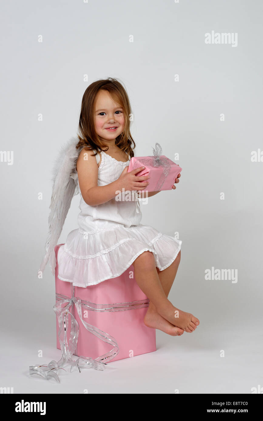 Mädchen als Engel mit Weihnachtsgeschenke Stockfoto