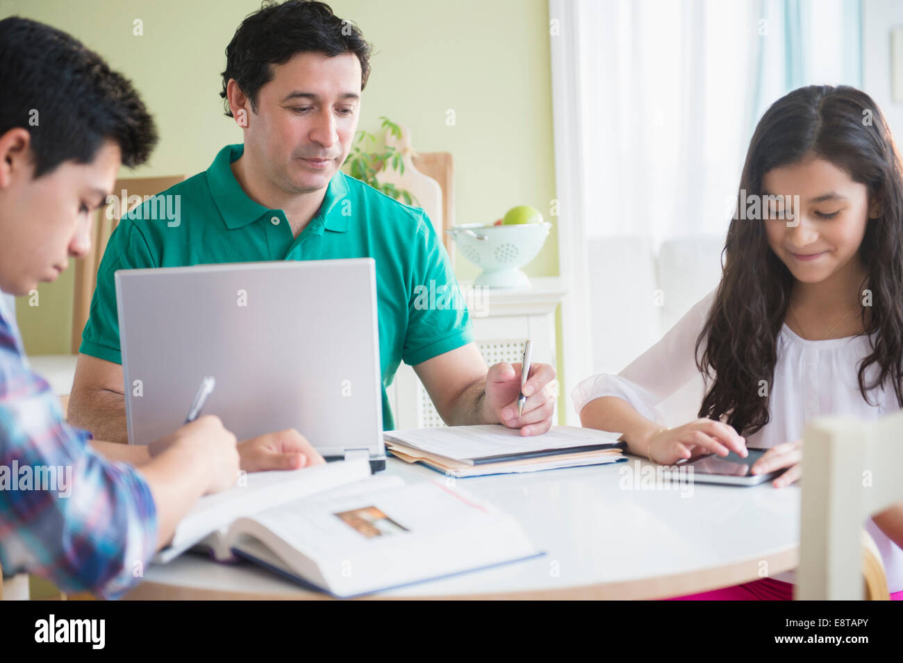 Hispanische Familie Hausaufgaben zusammen am Tisch Stockfoto