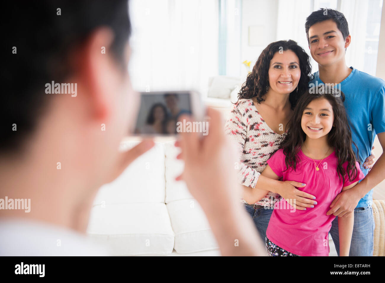 Hispanische Familie Handy fotografieren im Wohnzimmer Stockfoto