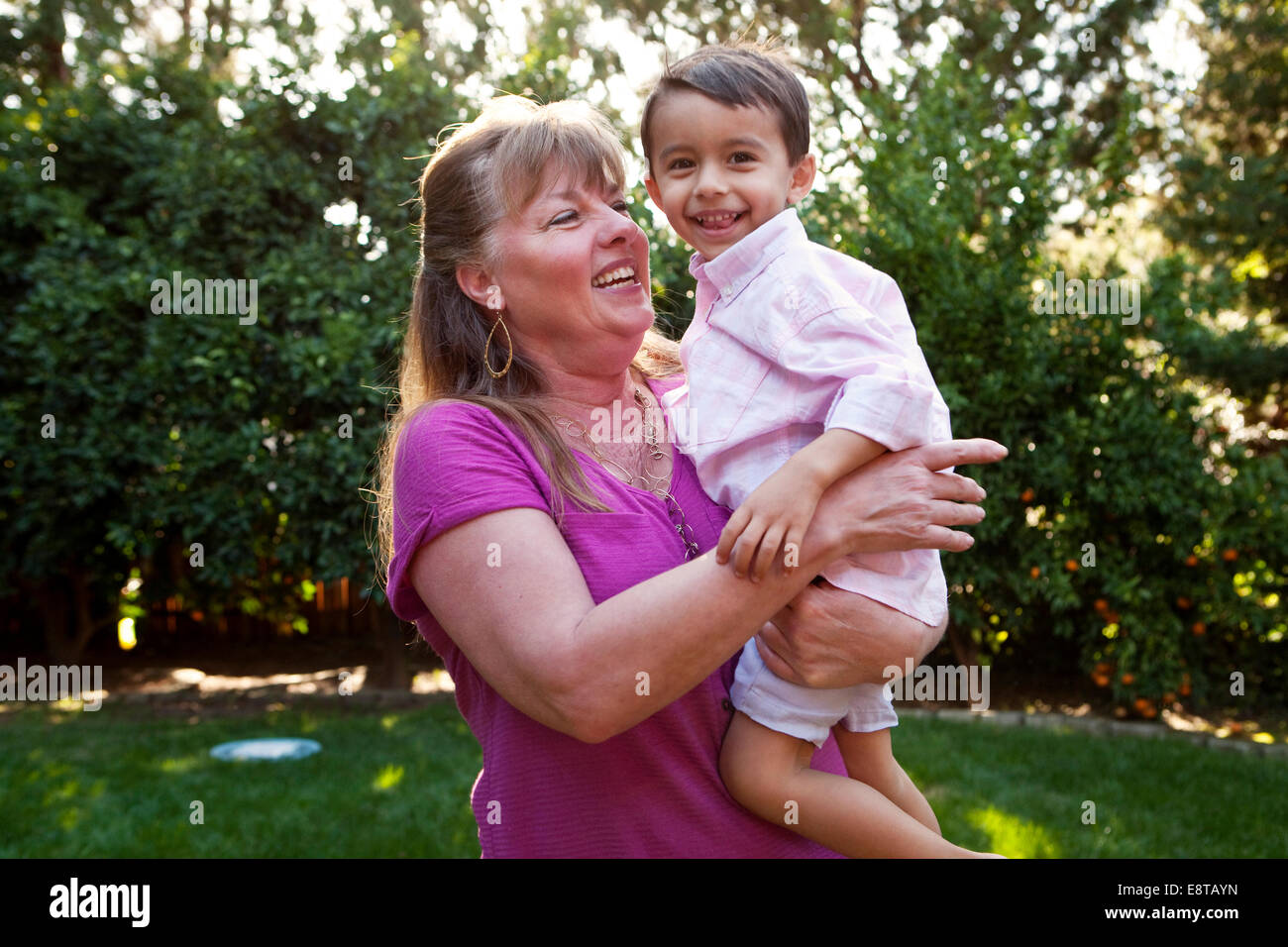 Großmutter Holding Enkel im Hinterhof Stockfoto