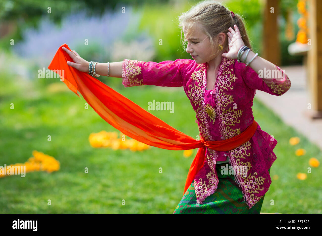 Kaukasische Mädchen tanzen darstellende Balinesen im Hinterhof Stockfoto