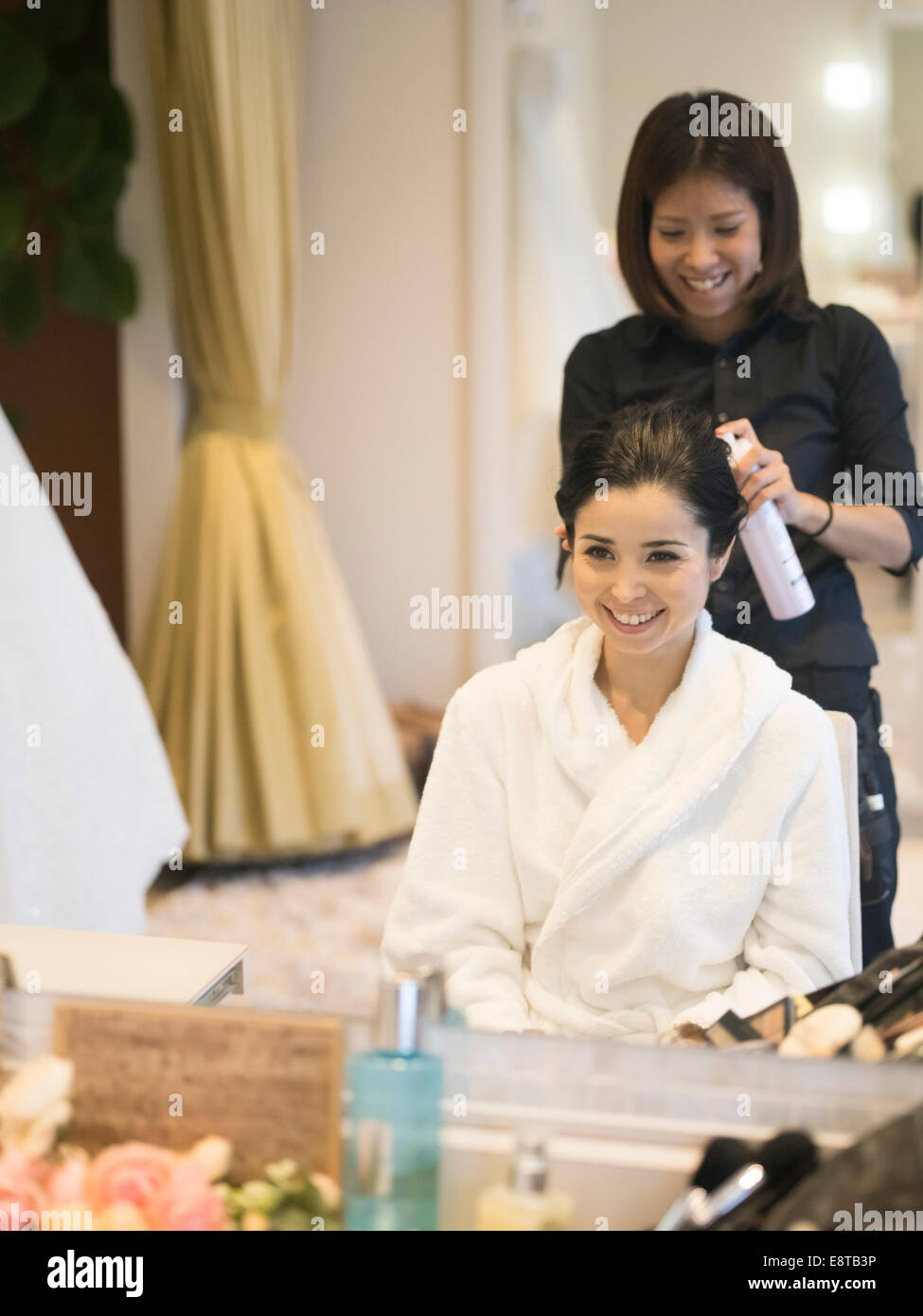 Gemischte Rassen, asiatische / American Braut hat Make-up und Haare gestylt von Stylist vor Hochzeit Stockfoto