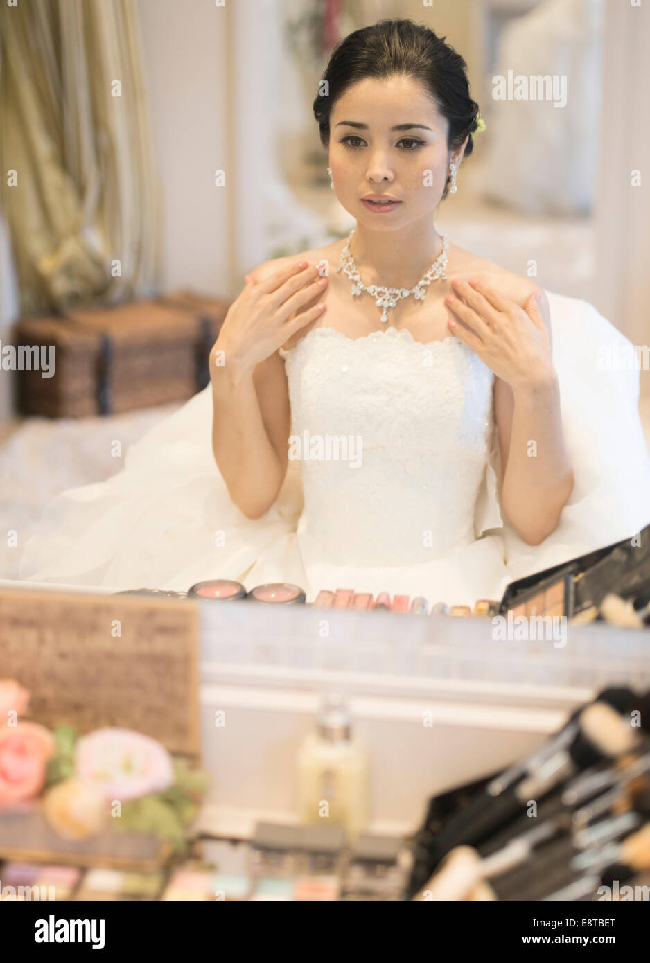 Mischlinge, asiatische / American Braut im weißen Brautkleid für ihre Hochzeit, Vorbereitung Prüfung Make-up und Haare. Stockfoto