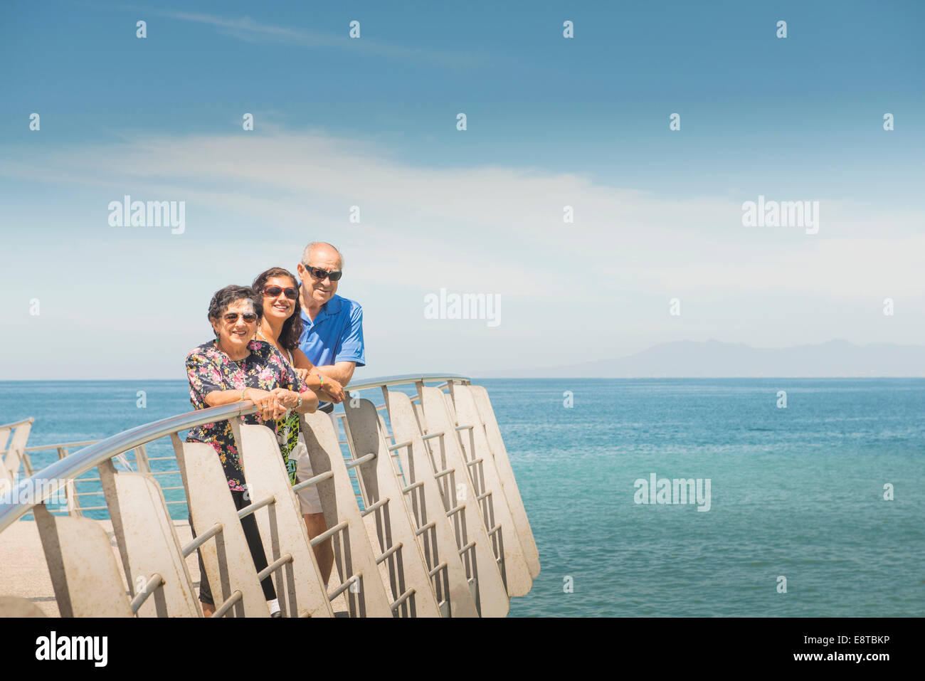 Familie lächelnd zusammen an Uferpromenade Reling Stockfoto