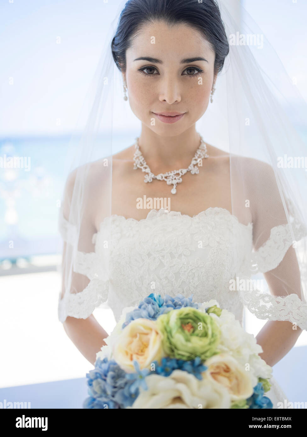 Mischlinge, asiatische / American Braut im weißen Hochzeitskleid am tropischen Strandhochzeit Stockfoto