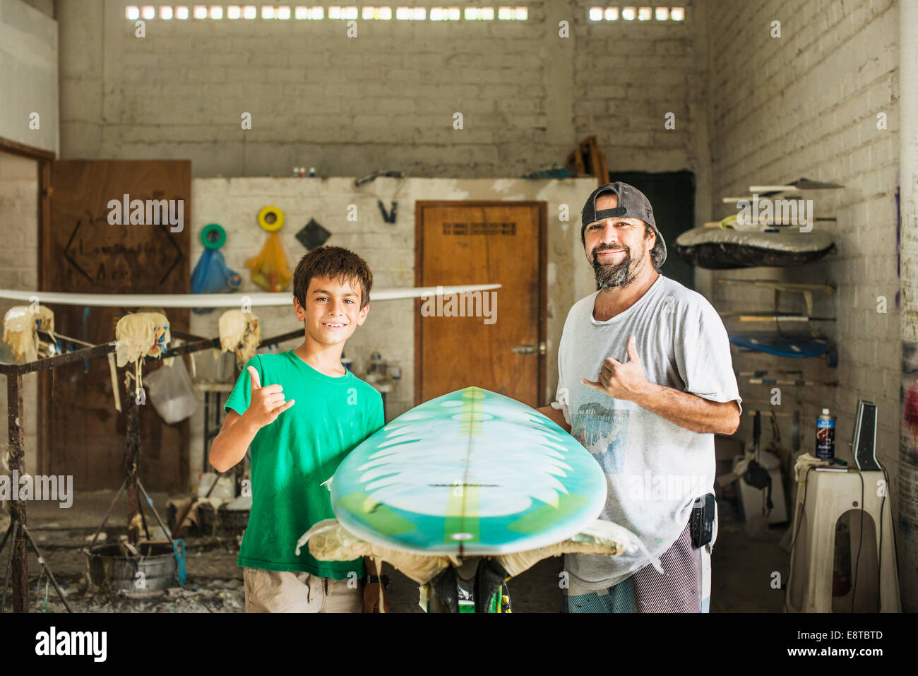 Vater und Sohn gestikulieren hängen zehn Surfbrett workshop Stockfoto