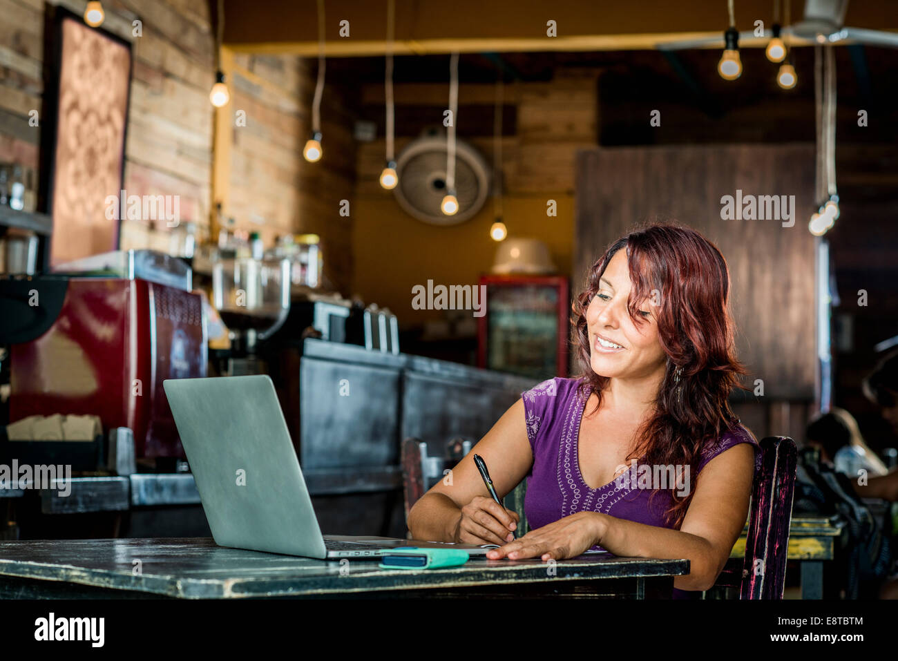 Hispanic Frau mit Laptop im Café Stockfoto