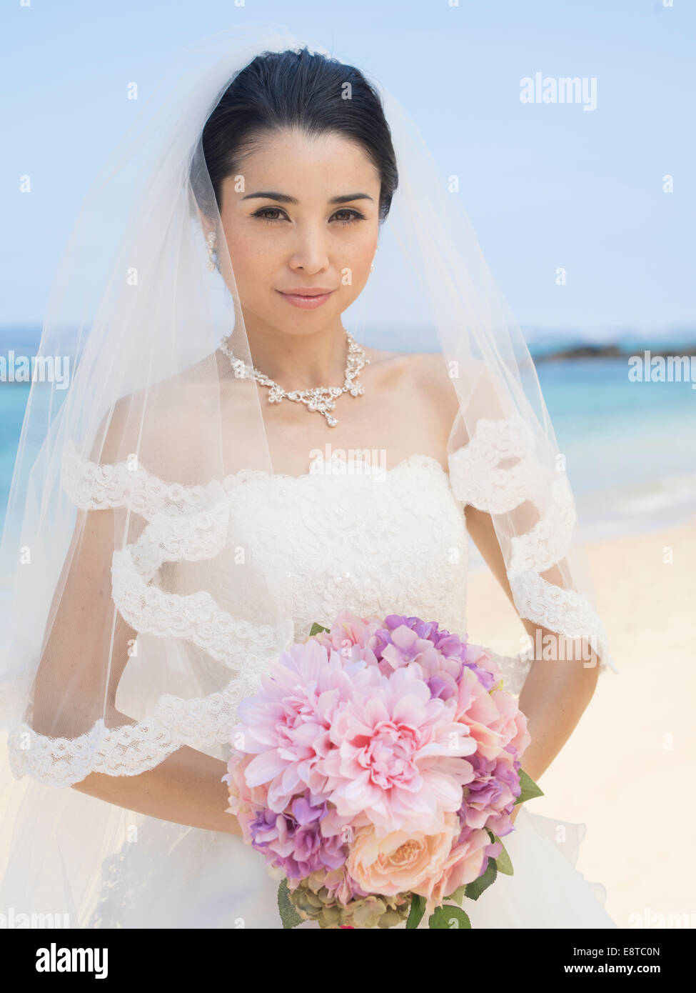 Mischlinge, asiatische / American Braut im weißen Hochzeitskleid am Strandhochzeit in Okinawa, Japan Stockfoto