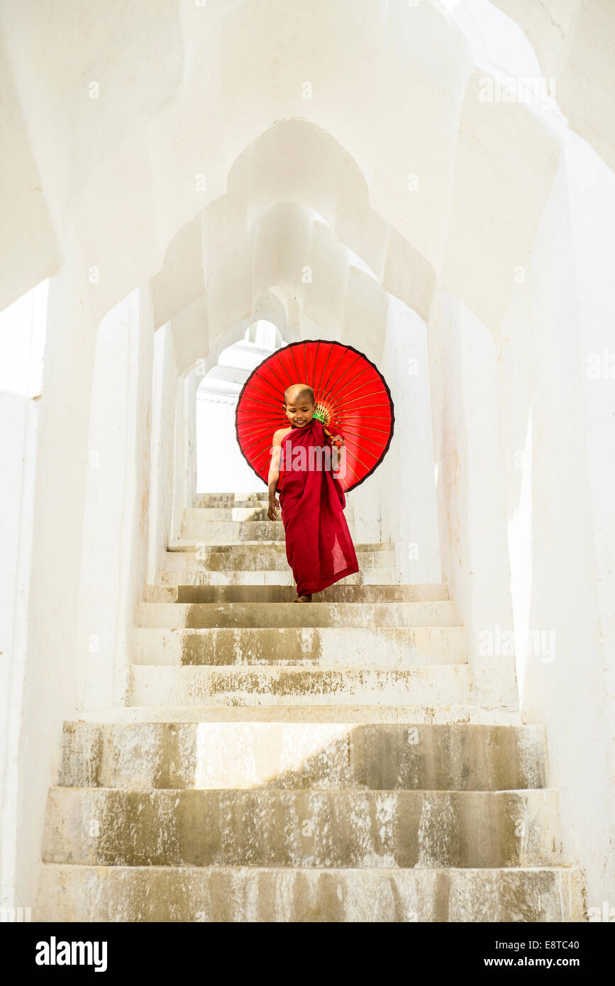 Asiatischer buddhistischer Mönch mit Regenschirm auf Treppe am Hsinbyume Pagode, Mandalay, Sagaing, Myanmar Stockfoto