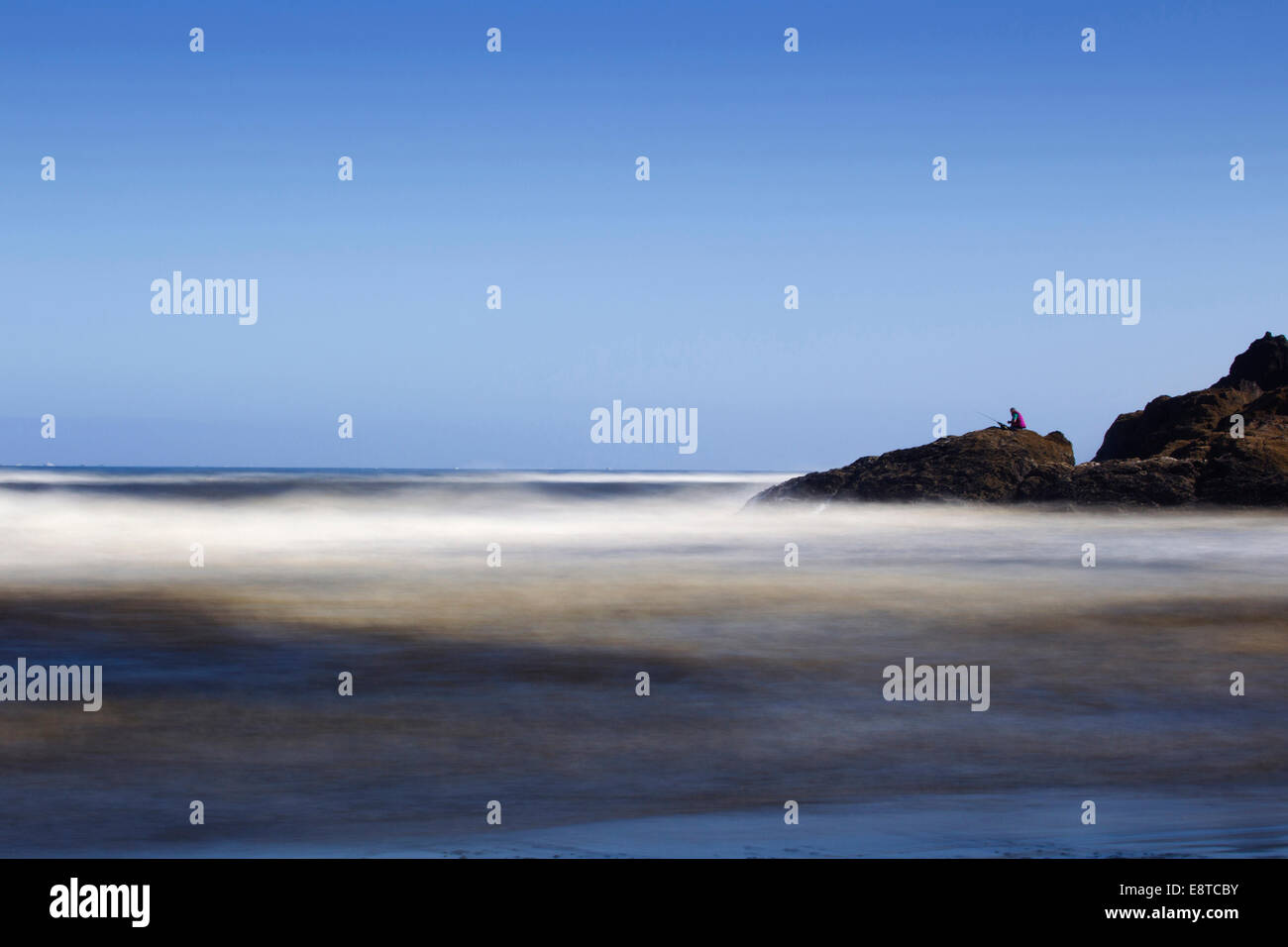 Verschwommene Wellen am felsigen Strand Stockfoto