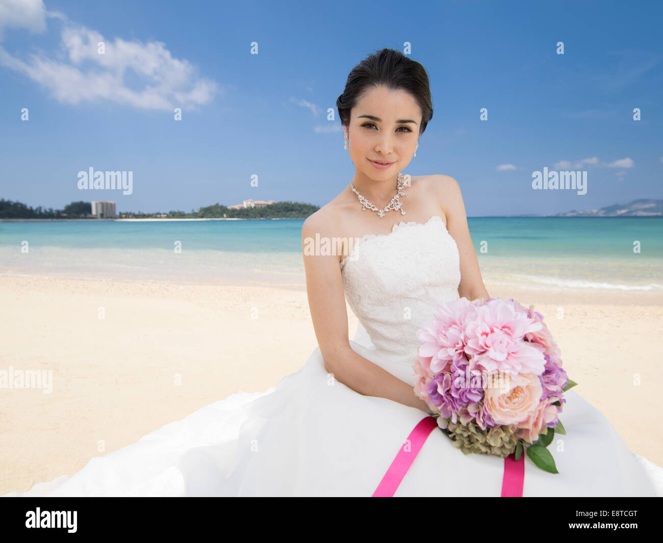 Mischlinge, asiatische / American Braut im weißen Hochzeitskleid am Strandhochzeit in Okinawa, Japan Stockfoto