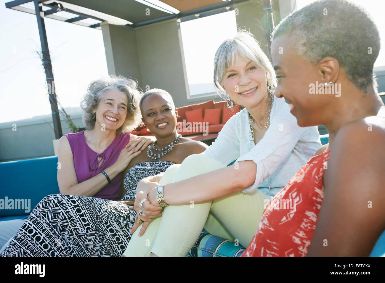 Frauen, die gemeinsam auf städtische Dachterrasse entspannen Stockfoto