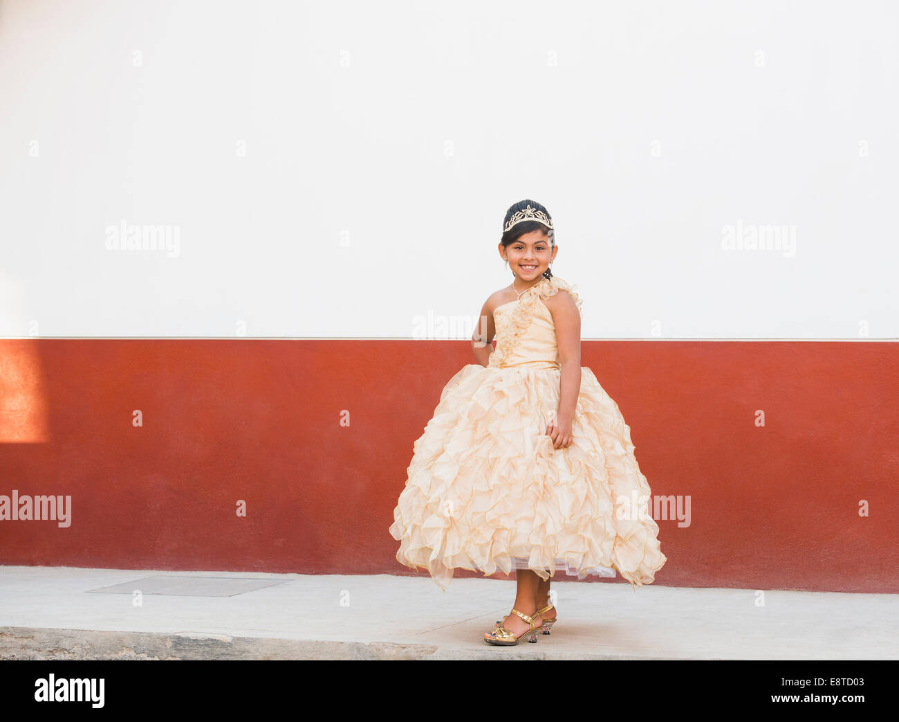 Hispanischen Mädchen posiert in kunstvollen Kleid und Diadem Stockfoto