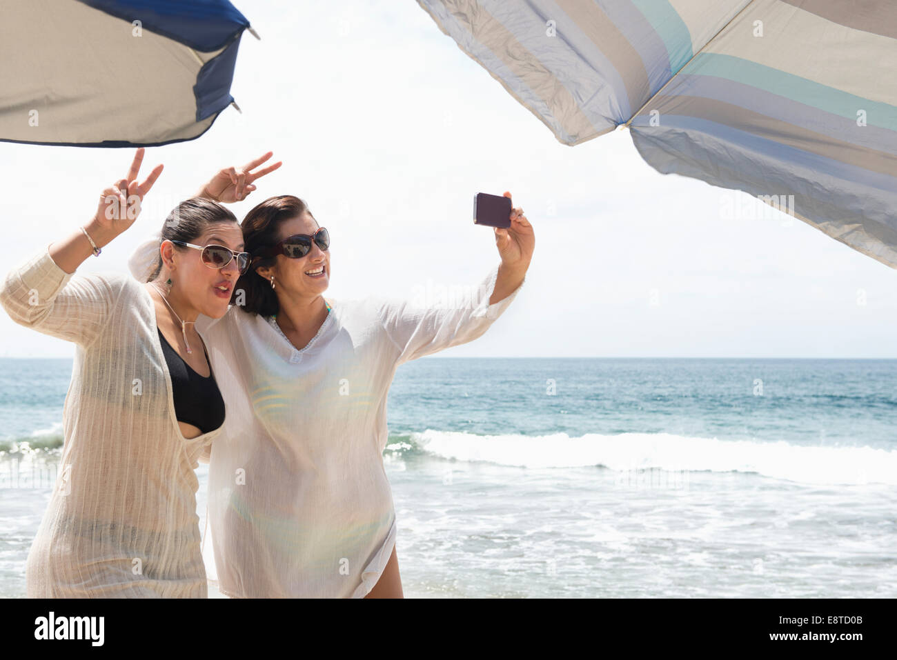 Hispanic Frauen, die die Handy-Selfie am Strand Stockfoto