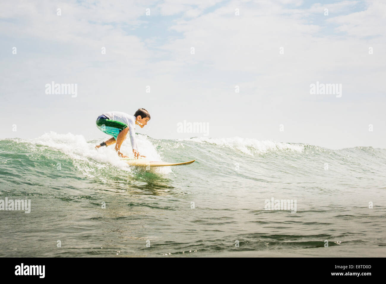 Gemischte Rassen junge Surfen in den Wellen Stockfoto