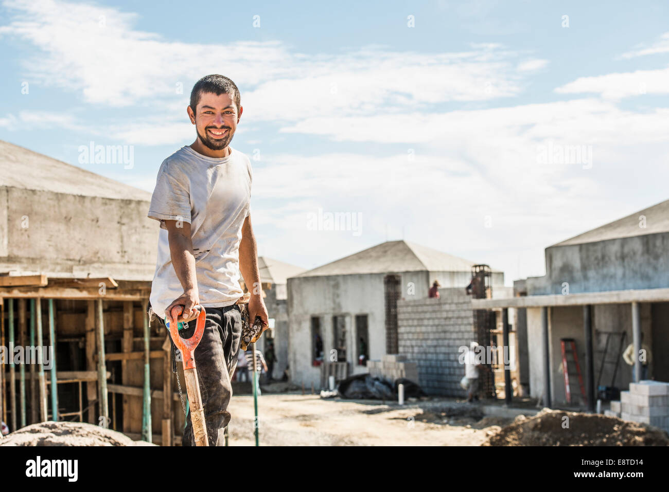 Hispanische Bauarbeiter mit Schaufel auf Baustelle Stockfoto