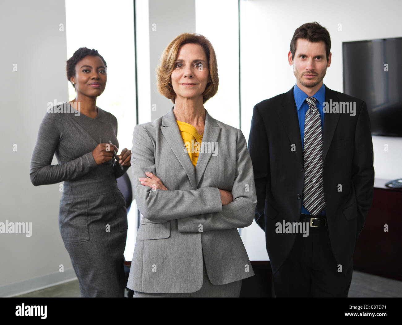 Geschäftsleute, die lächelnd zusammen im Büro Stockfoto