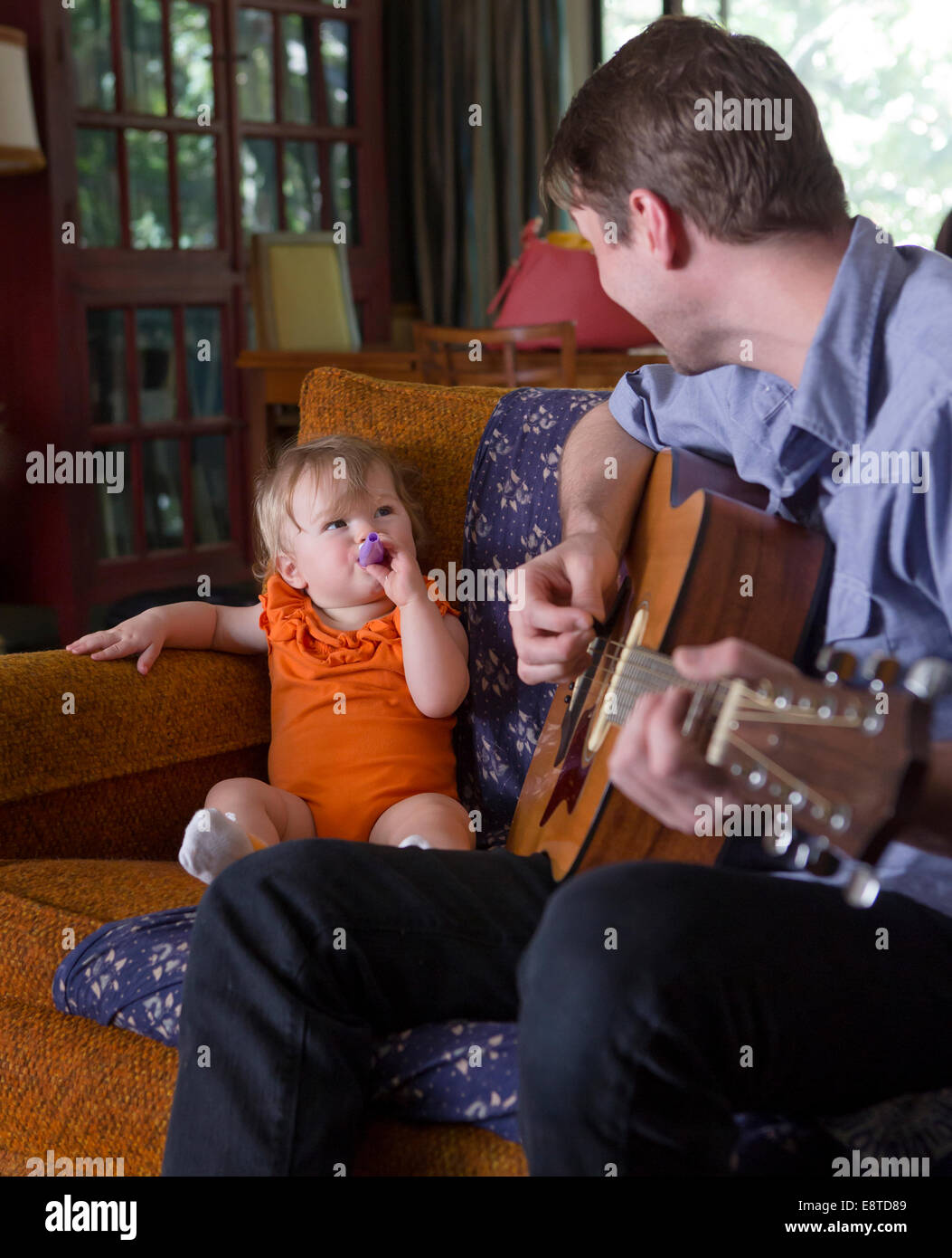 Kaukasische Vater spielte Gitarre für Tochter Stockfoto