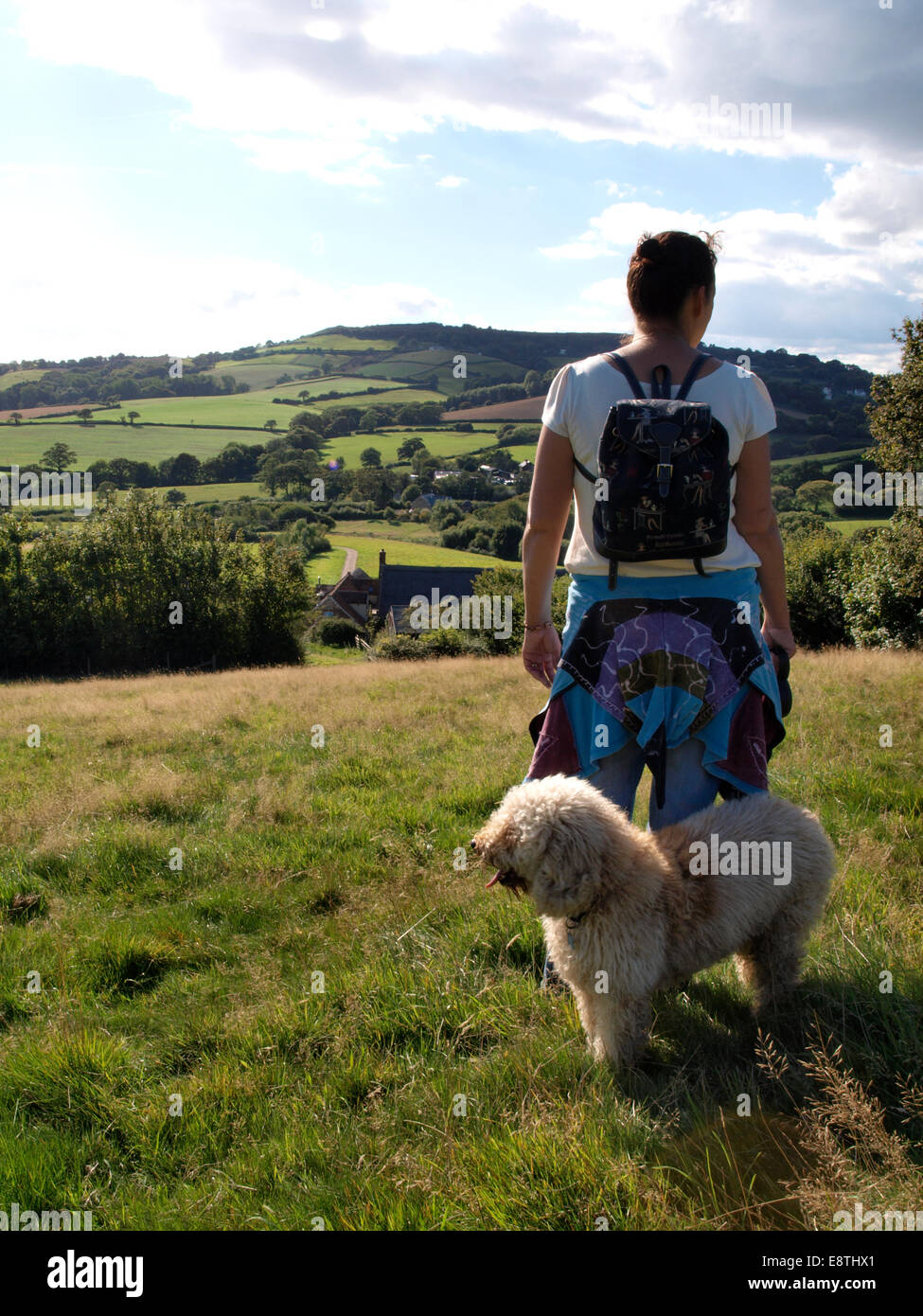Frau mit Hund betrachten des Dorset Landschaft, Chideock, Dorset, Großbritannien Stockfoto