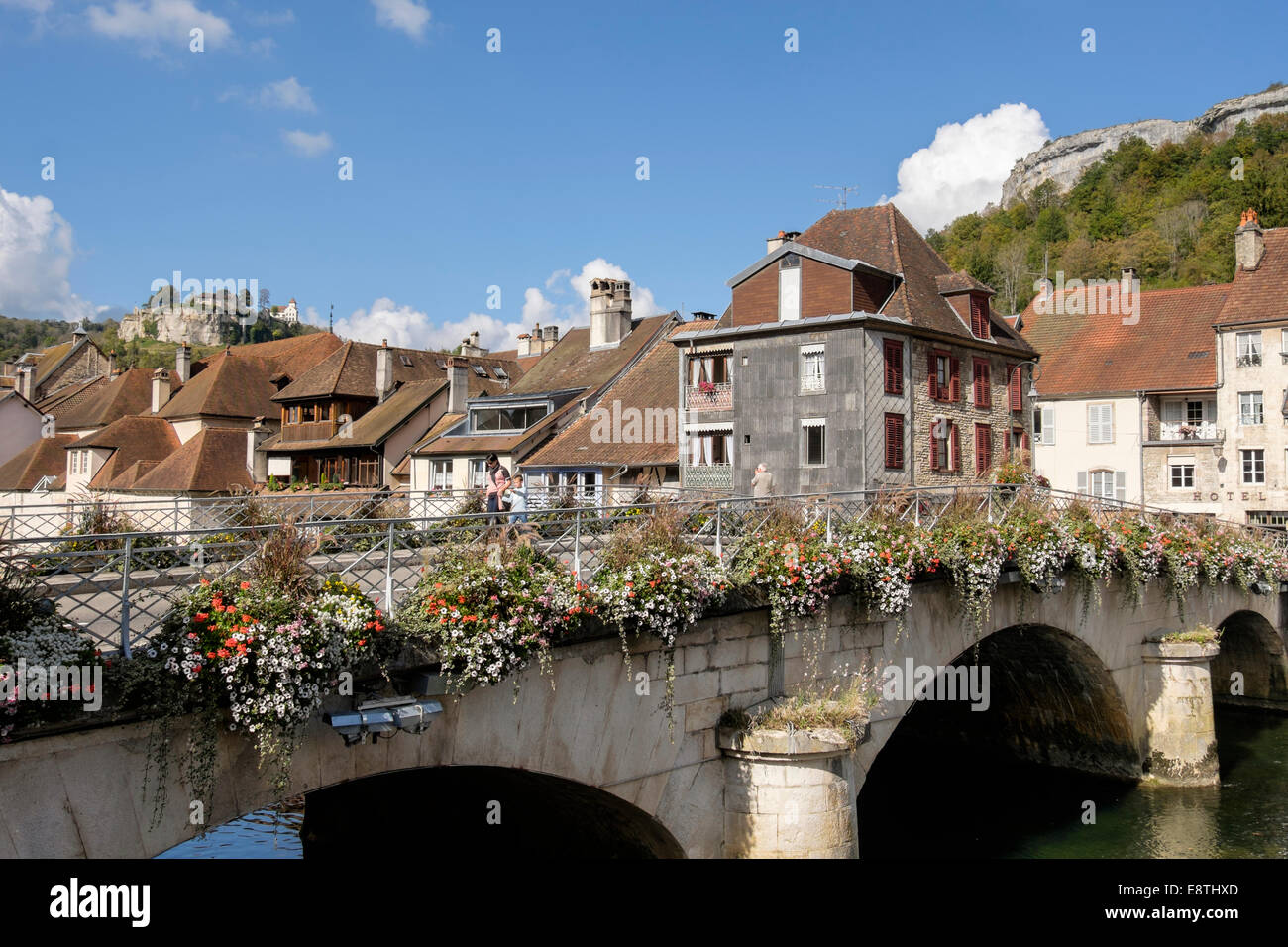 Loue Flussbrücke mit Blumen und Höhenburg oberhalb der Stadt. Ornans, Doubs, Franche Comte, Frankreich, Europa Stockfoto