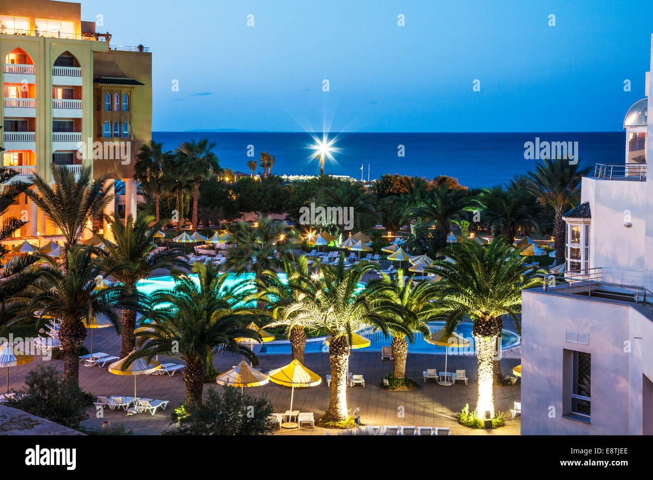 Dämmerung Blick auf den Poolbereich eines fünf-Sterne-Resort-Hotels in der Nähe von Port el Kantoui in Tunesien mit dem Mittelmeer. Stockfoto
