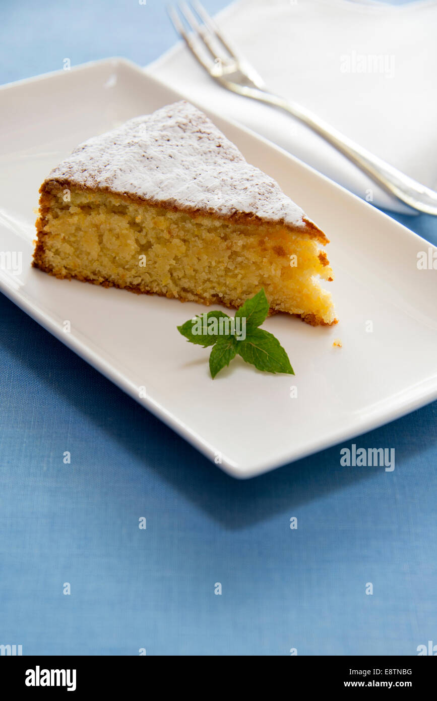 Eine Scheibe orange-Mandel-Kuchen auf einem weißen Teller. Stockfoto