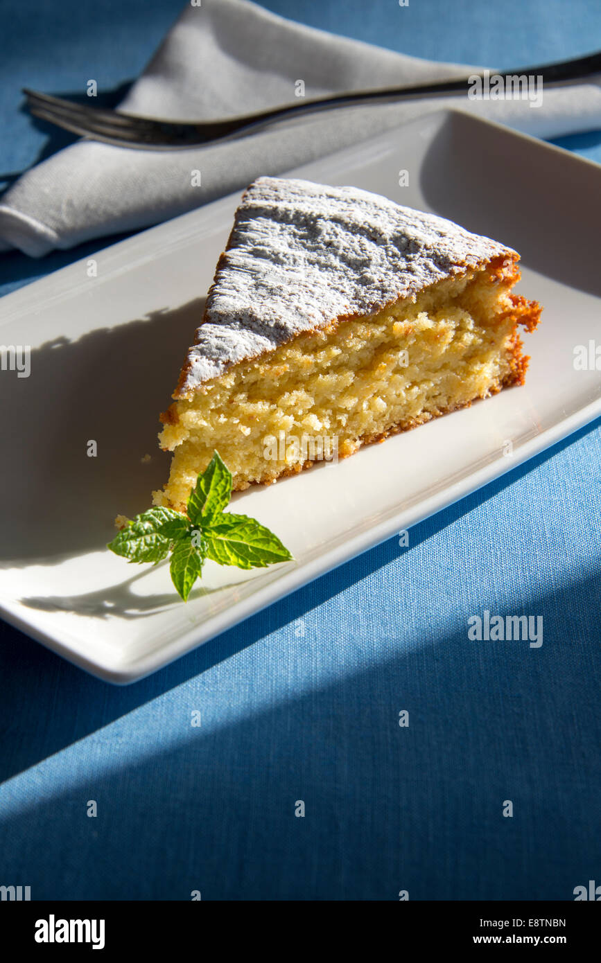 Eine Scheibe orange-Mandel-Kuchen auf einem weißen Teller. Stockfoto