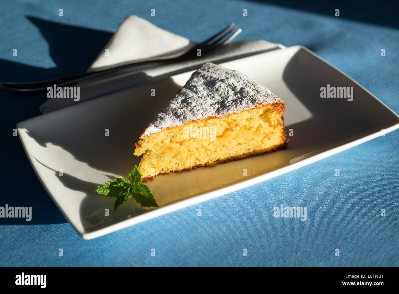 Eine Scheibe orange-Mandel-Kuchen auf einem weißen Teller. Stockfoto