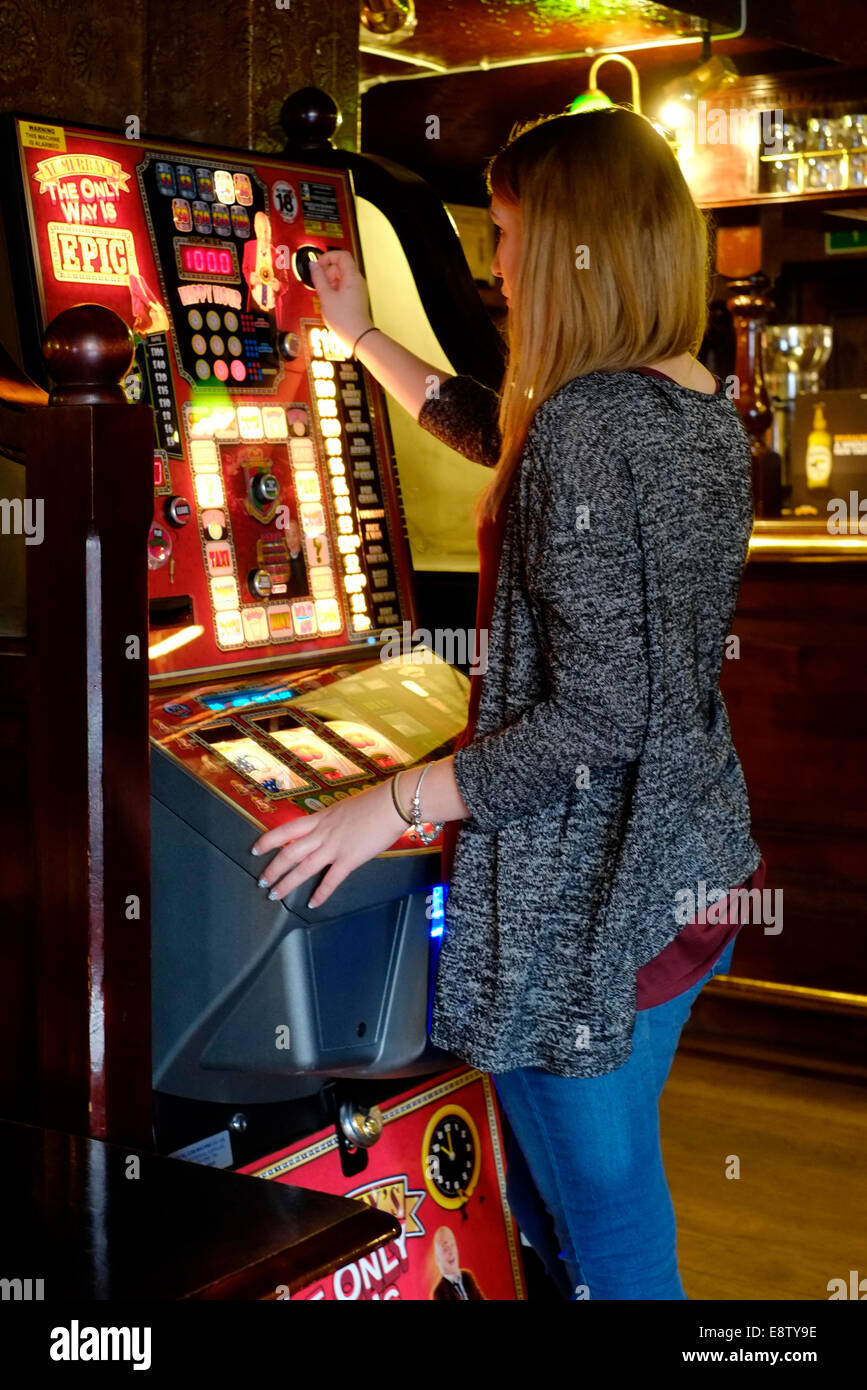 junge Frau auf einem Spielautomaten in einem traditionellen britischen Pub Eldon Arme Southsea England Großbritannien spielen Stockfoto