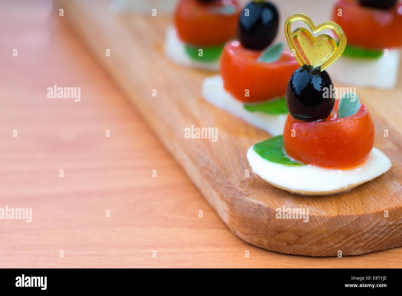 Einfachen Snack Canape mit Tomaten, Mozzarella und Basilikum Nahaufnahme auf hölzernen Hintergrund Stockfoto