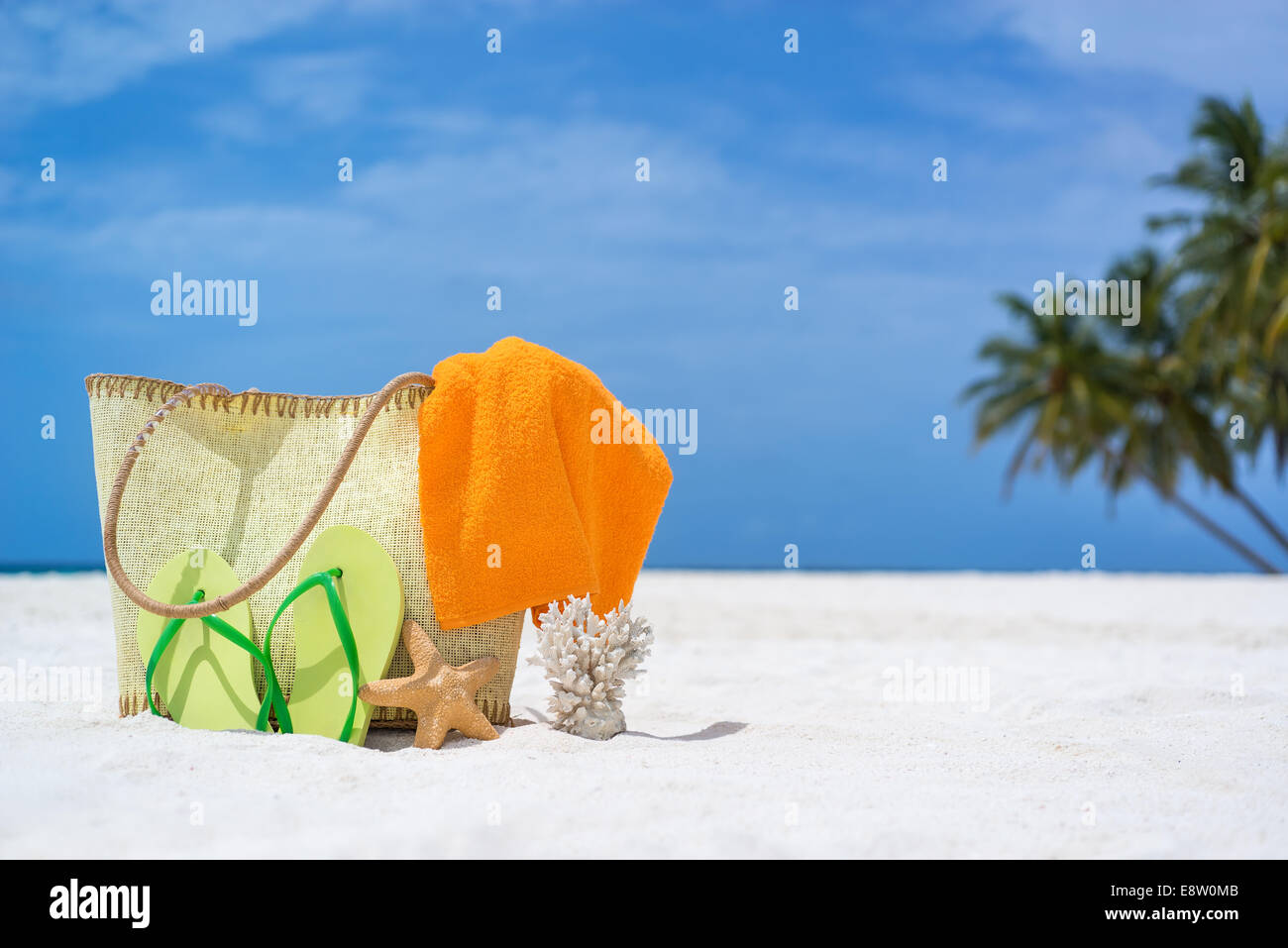 Sommer-Strand-Tasche mit Seestern, Handtuch, Burschen gesungen und Flip-Flops am Sandstrand Stockfoto