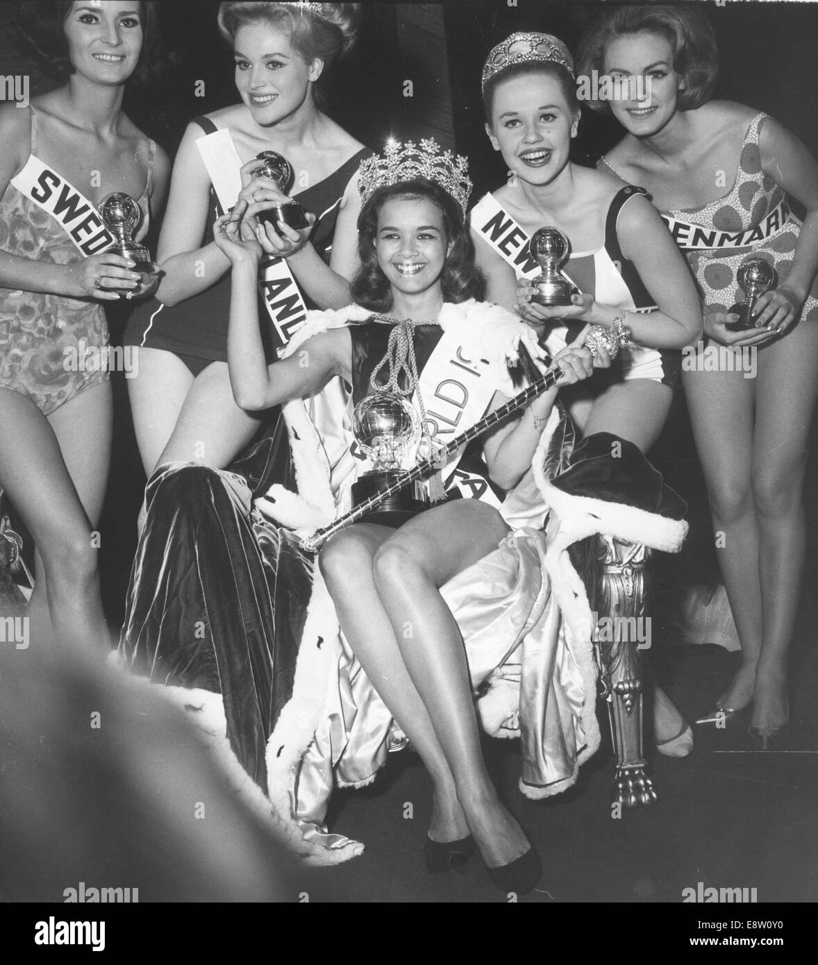 8. November 1963 - sitzt London, England, Vereinigtes Königreich - Miss Jamaica CAROLE JOAN CRAWFORD auf ihrem Thron nach dem Titelgewinn der Miss-World-1963. Sie ist umgeben von L-R Miss Schweden Greta Quiberg, 5., Miss Finnland Marja-Liisa Stahlberg, 3. aufgegeben, Miss New Zealand Elaine Miscall, die 2. und Miss Dänemark Aino Korva, 4. aufgegeben, aufgegeben. Im Alter von 20 machte die 5'3 ' (1,59 m) Schönheit, Miss World Standards, kurze Geschichte, indem er den ersten Delegierten aus ihrer Heimat, den Titel zu gewinnen. Die Veranstaltung fand im Lyceum Ballroom in London statt. Jamaika-Post eine Briefmarke von ihr Gesicht in honou Stockfoto