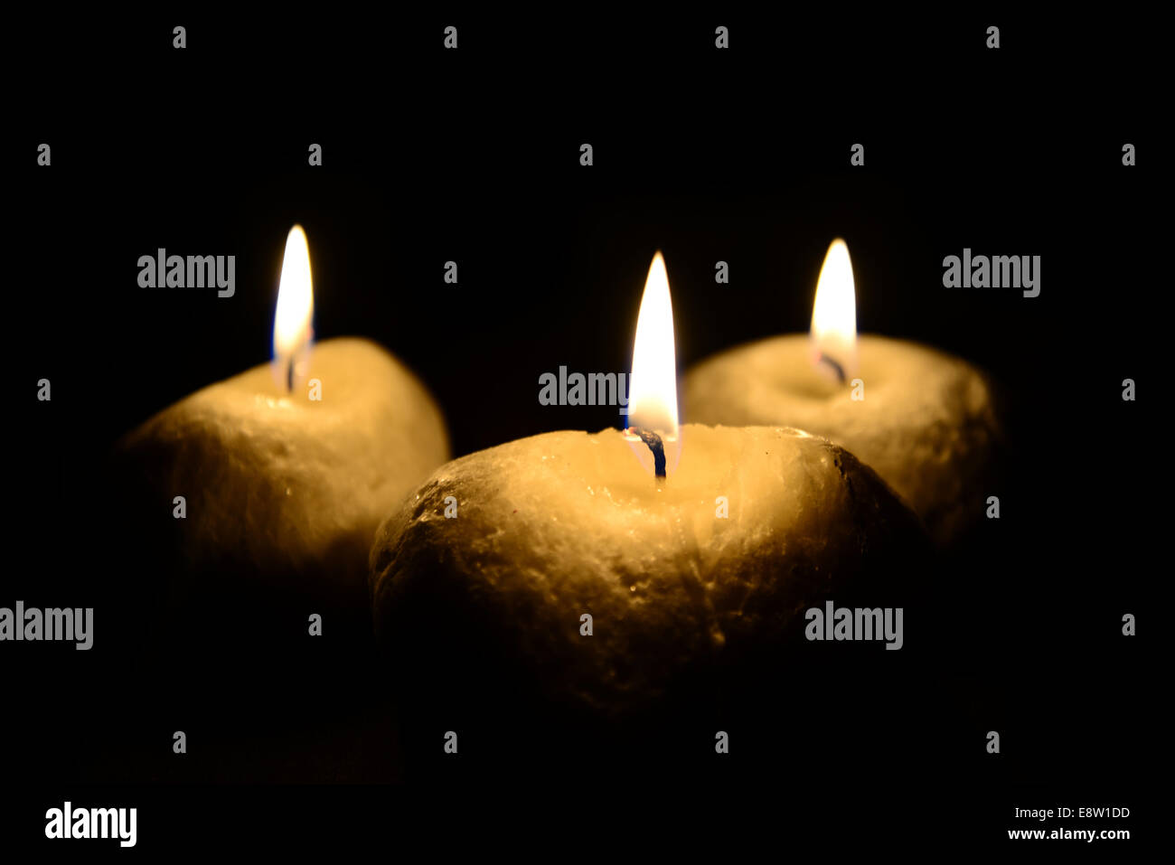 Drei Kerzen, die isoliert auf schwarz Stockfoto